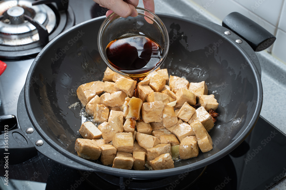 在家庭厨房的煤气炉上烹饪豆腐丁，生活方式，特写。