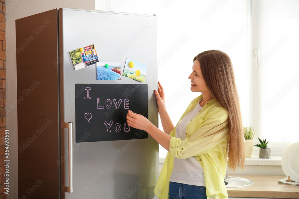 年轻女子在厨房的黑板上写下我爱你