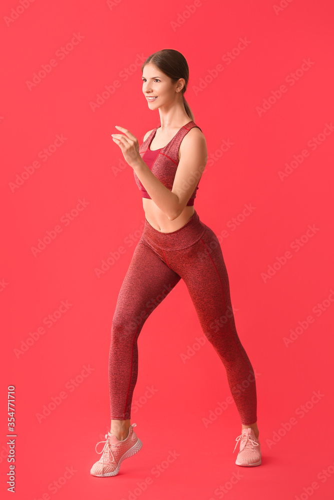运动型年轻女性在彩色背景下训练