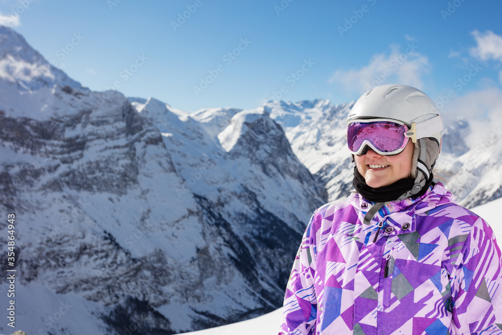 快乐少女微笑的近照戴着可爱的冬季滑雪服眼镜，戴着登山帽