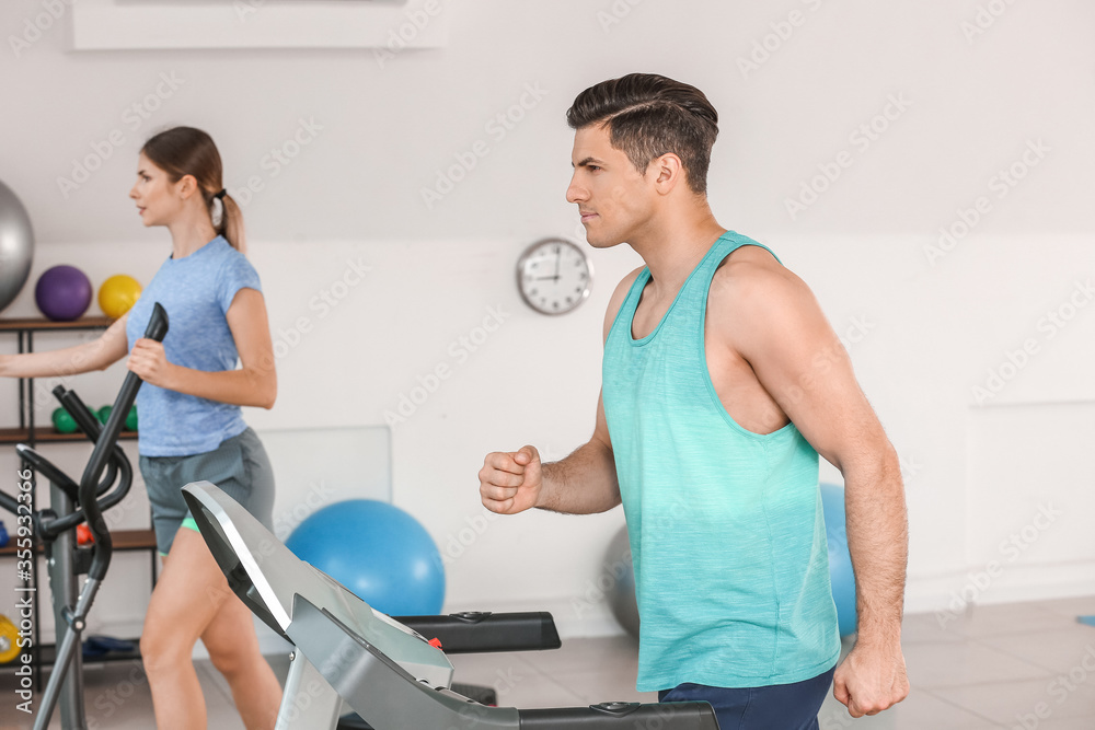 Sporty young couple training in gym