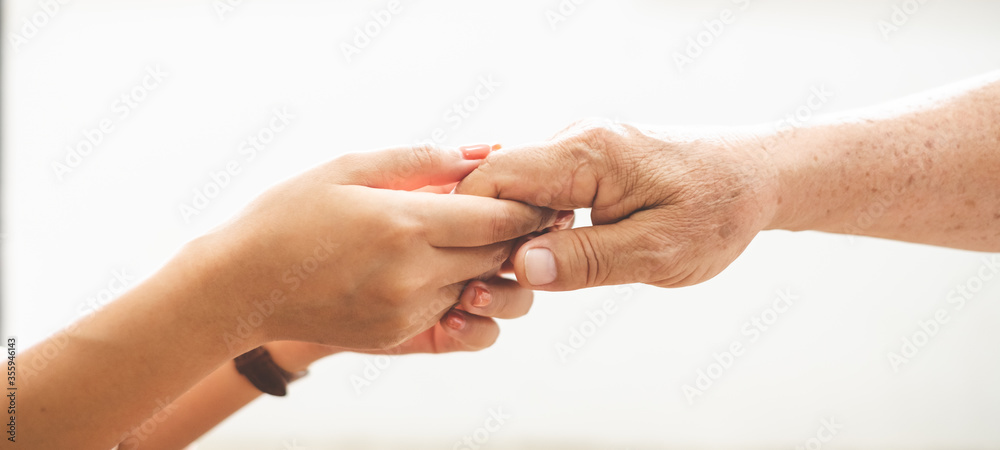 女人用爱和关怀牵着老年长者的手