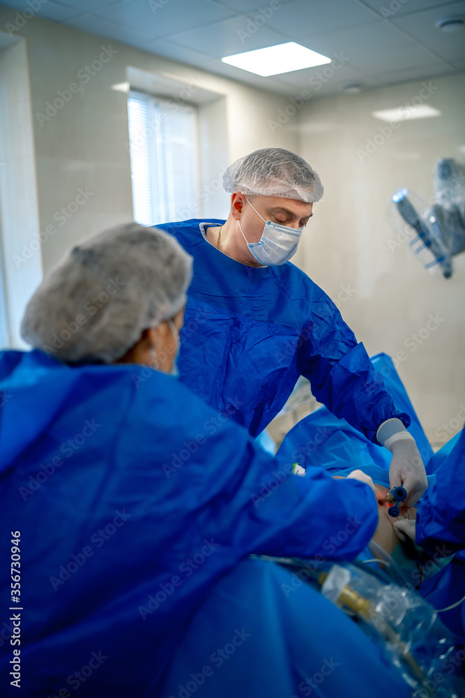 使用医疗设备进行手术的过程。外科医生在手术室使用手术设备