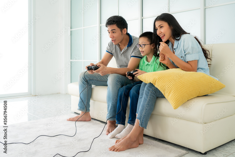 亚洲家庭父子在hom的客厅里一起玩电脑游戏玩得很开心