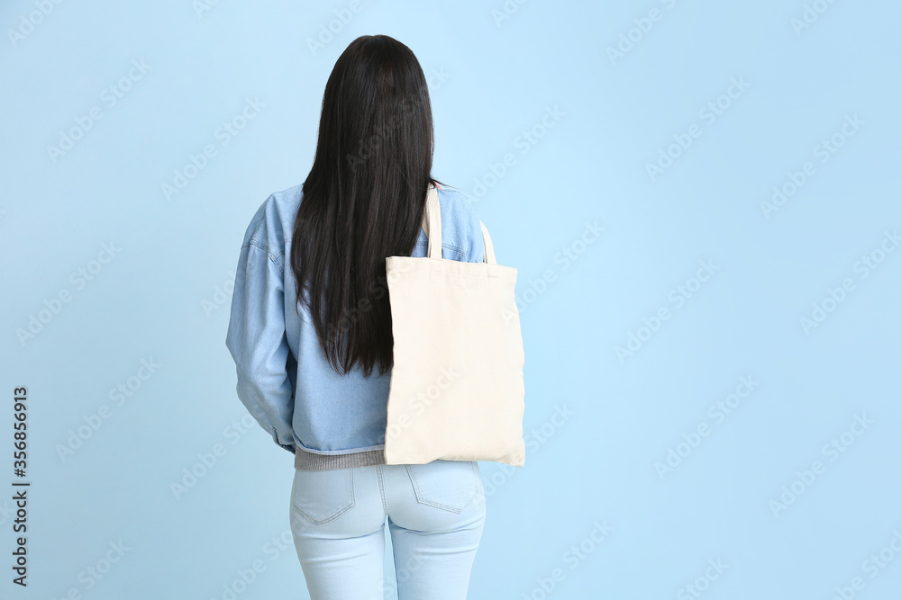彩色背景环保袋的年轻女性，后视图