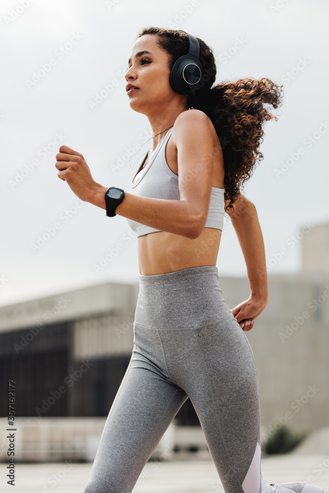 Athletic woman running through the city