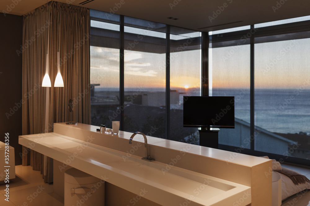 Modern sink in bedroom overlooking ocean at sunset