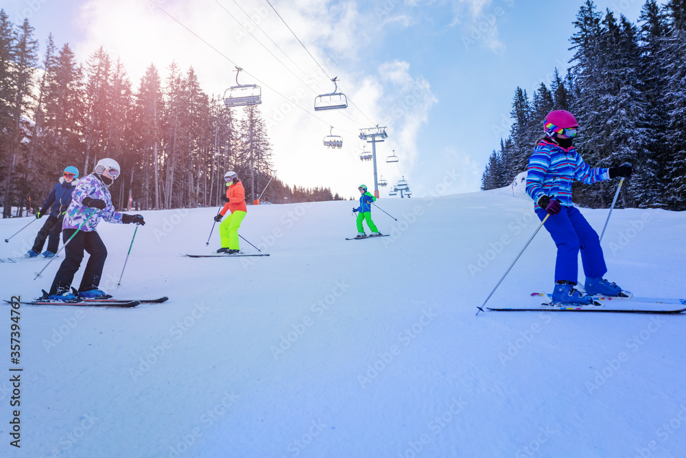一群十几岁的孩子在山上一起滑雪，背景是升降椅
