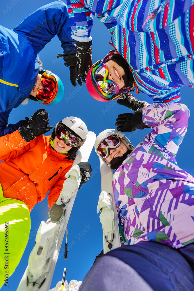 一群十几岁的女孩穿着滑雪服和冬季运动服站在一起微笑着俯视