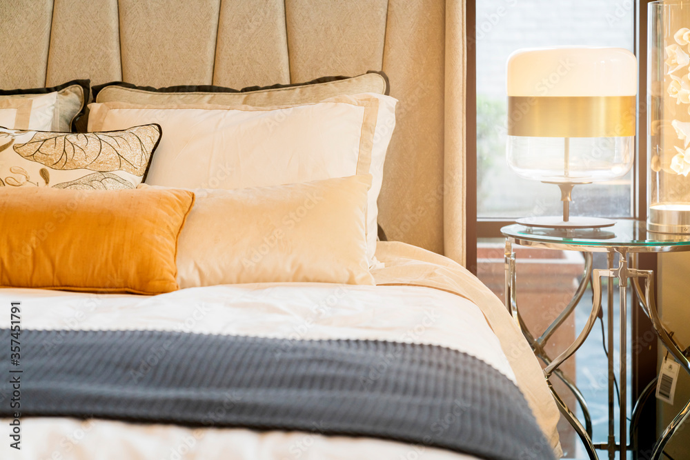 床上的近距离白色米色软枕头和毯子卧室室内设计概念。床上女仆豪华