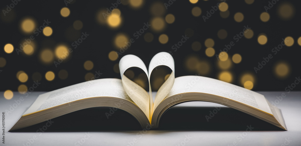 Heart-shaped folding book in the golden bokeh backdrop, Concept ideas for reading and love, soft-foc