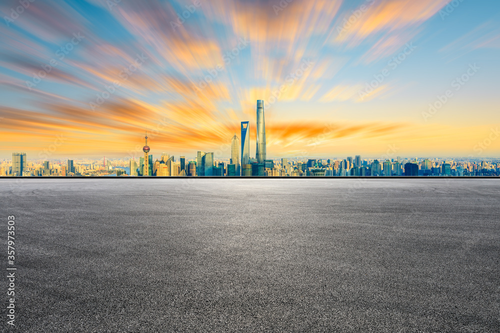Empty racing track road and Shanghai skyline with buildings at sunset.