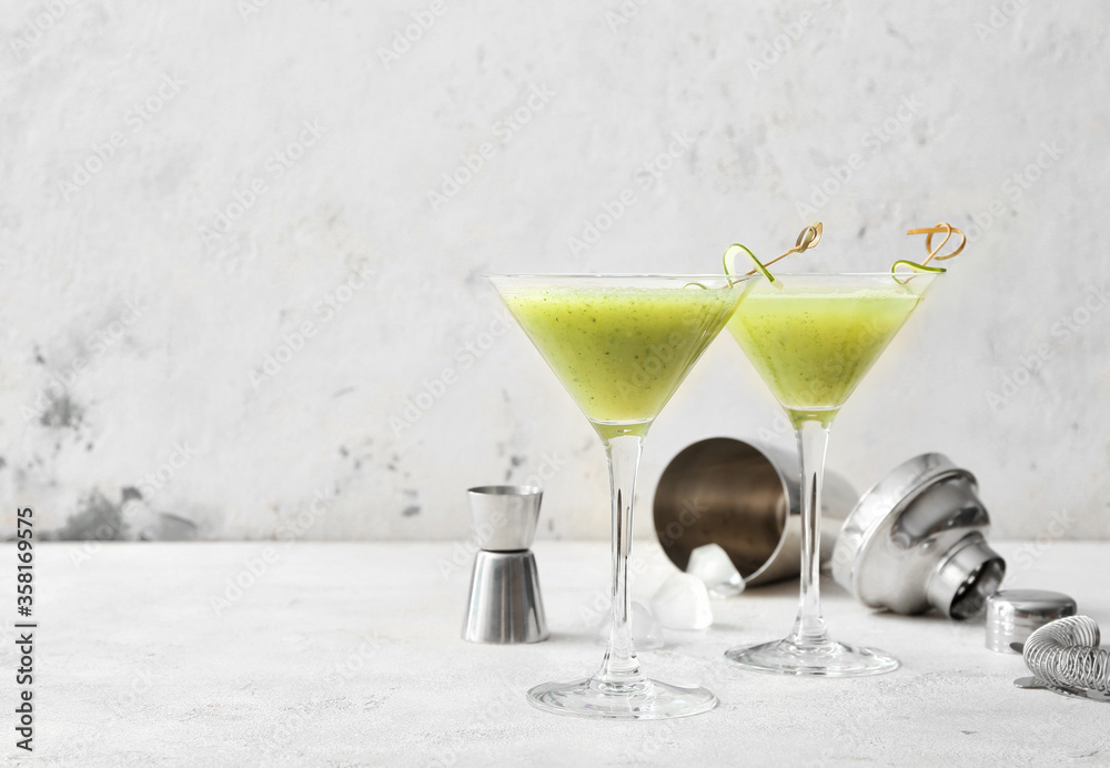 Glasses of tasty cucumber martini on white background