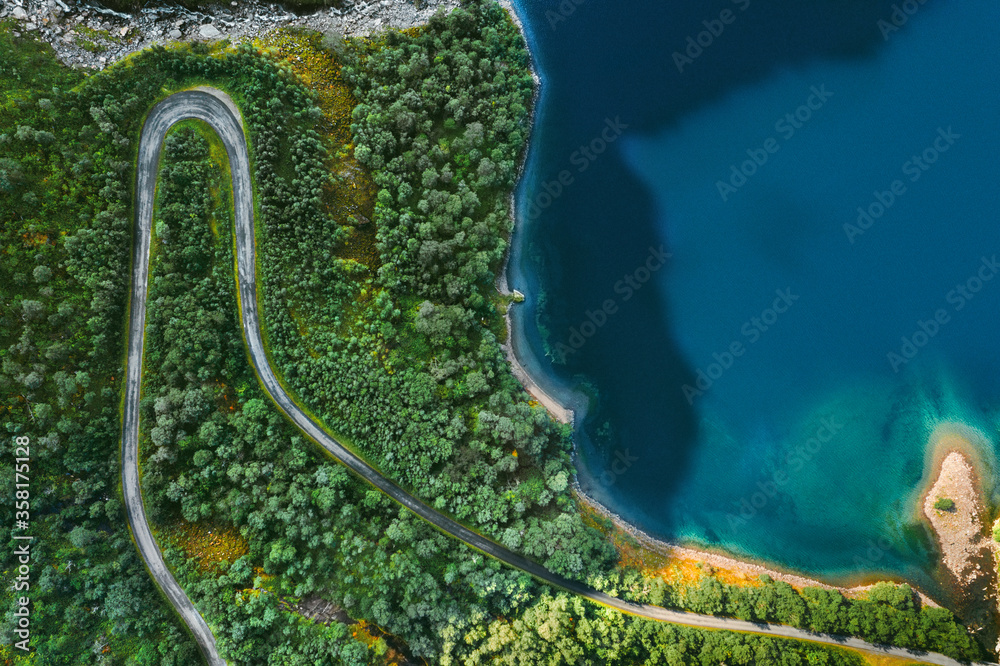 鸟瞰挪威蜿蜒的道路和森林，树木和蓝色大海上方有无人机景观