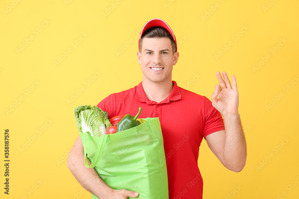 外卖员拿着袋子里的食物，在彩色背景上显示OK手势