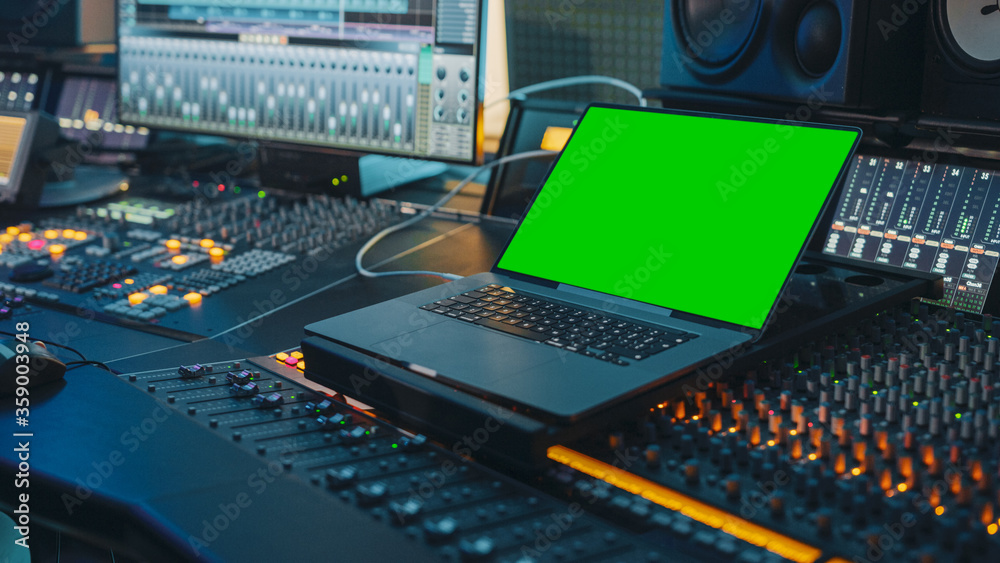 现代音乐唱片工作室控制台，配有绿屏Chroma Key笔记本电脑、均衡器、混音器等