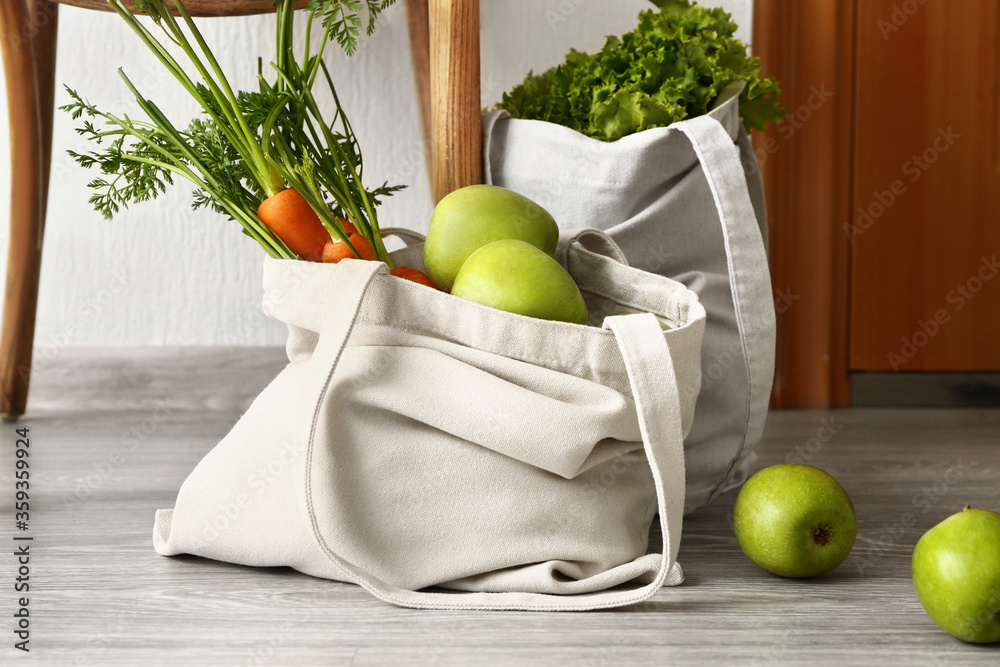 Eco bags with fresh products from market in hall
