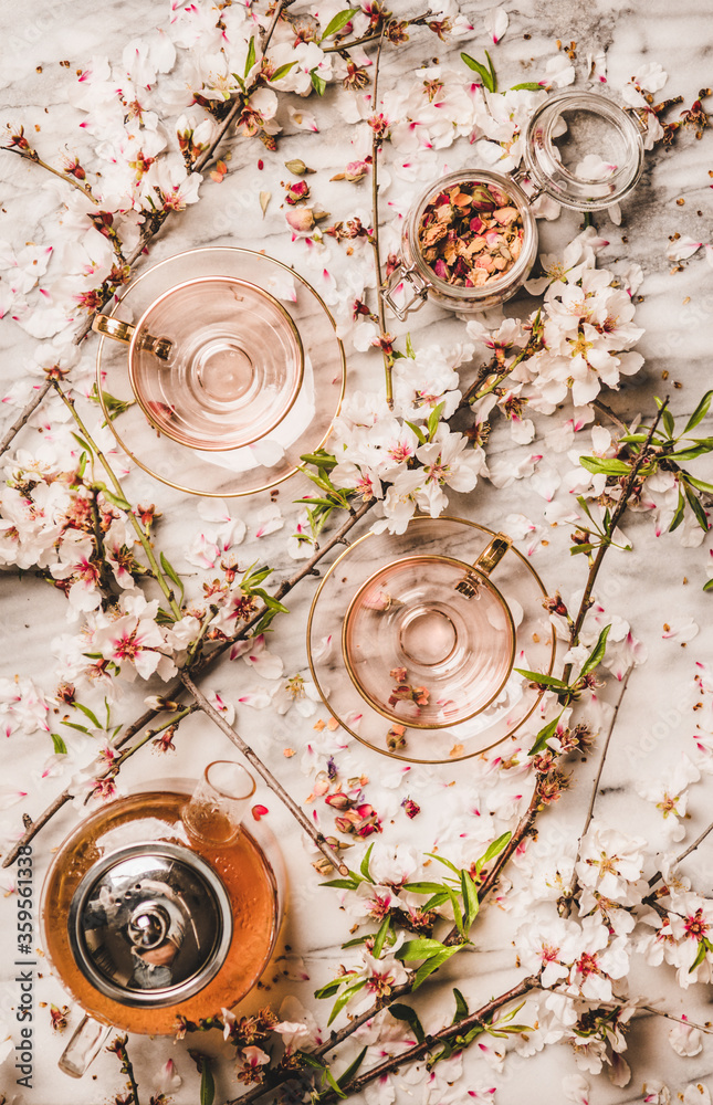 茶壶里的热红茶、玻璃杯、罐子里的干玫瑰花和春花杏仁