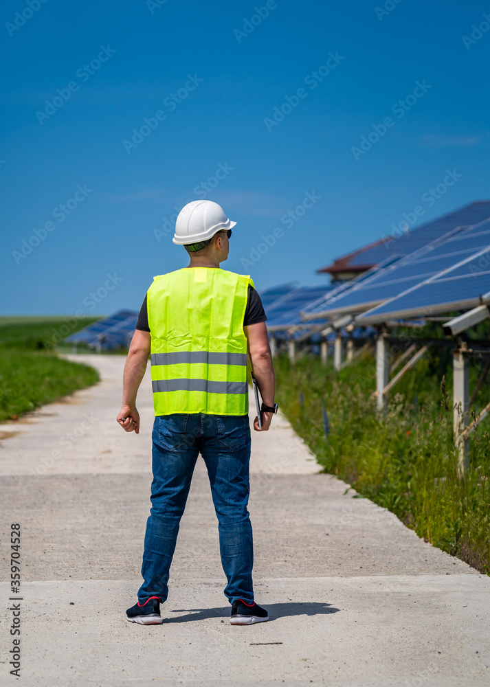 绿色新能源的概念。太阳能发电厂的工程师。从后面看。