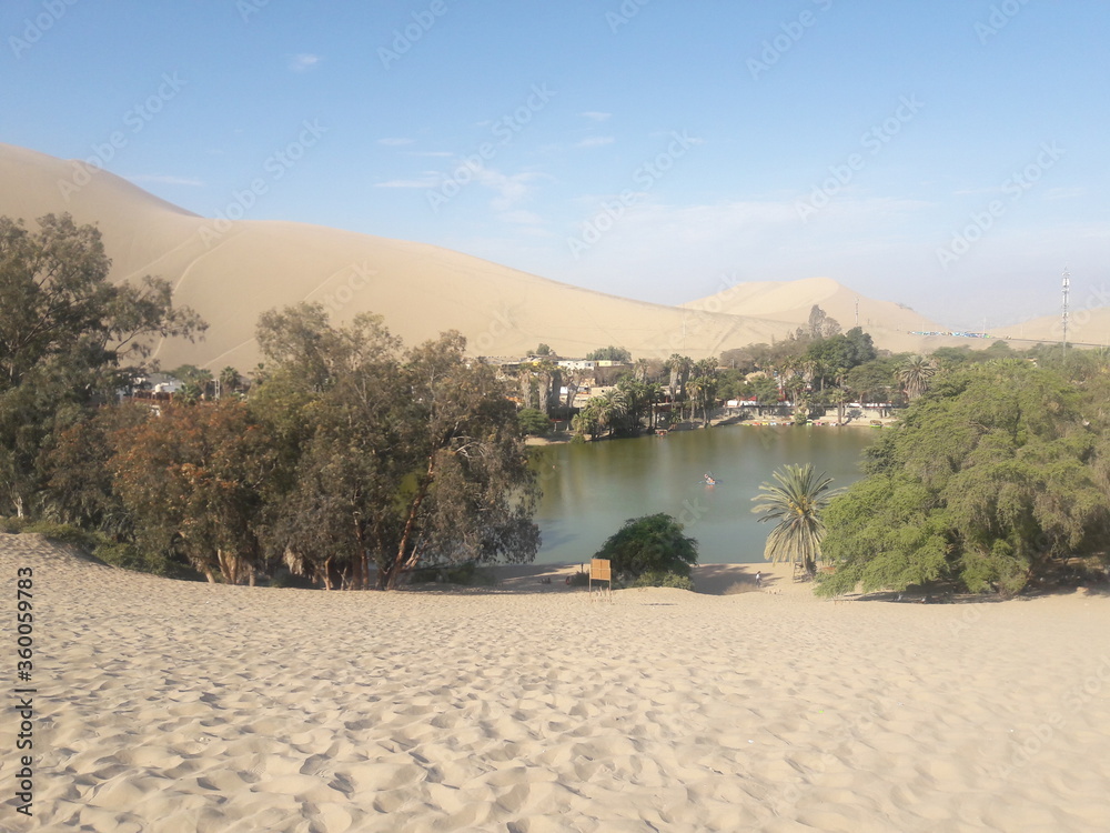 Huacachina Peru desert oasis water reservoir and palm trees 2019