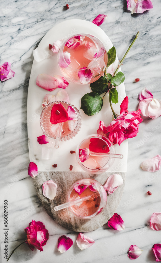 夏日清爽冷饮。平躺的玫瑰柠檬水，杯子里有冰块和粉红色的玫瑰p