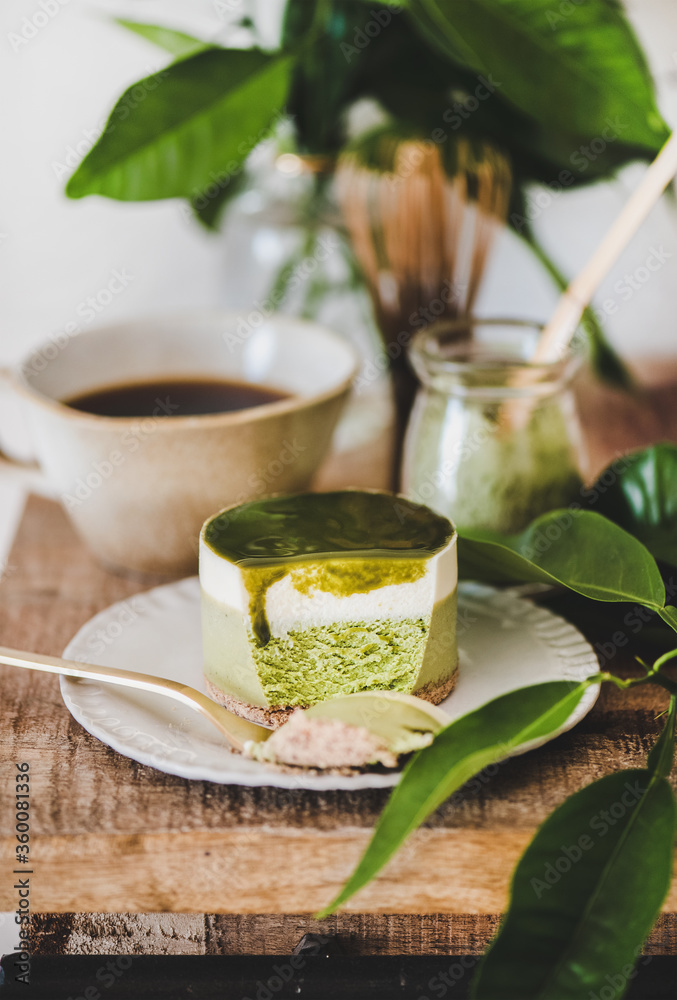 咖啡和甜点设置。绿色抹茶芝士蛋糕和冲泡的倒咖啡，放在乡村的木头上