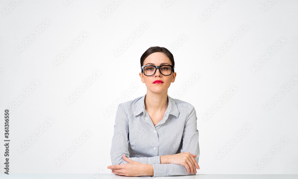 戴着眼镜坐在办公桌前的自信女商人