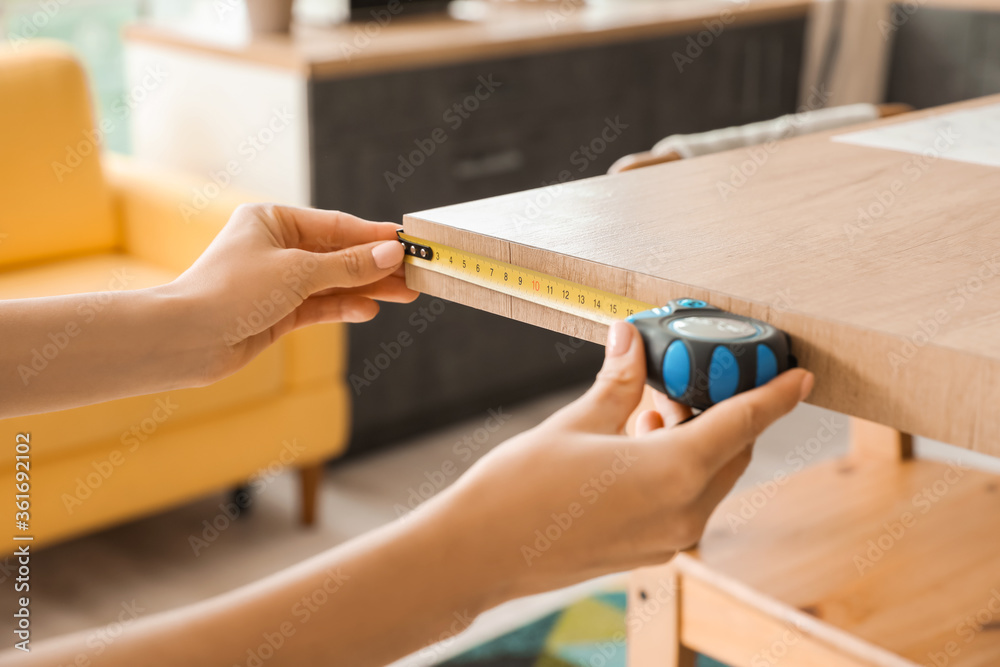 年轻女子在厨房里测量桌子，特写镜头