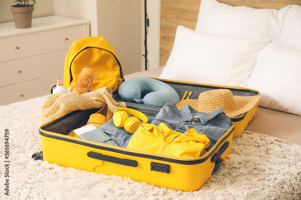 打包行李箱躺在床上。旅行理念
