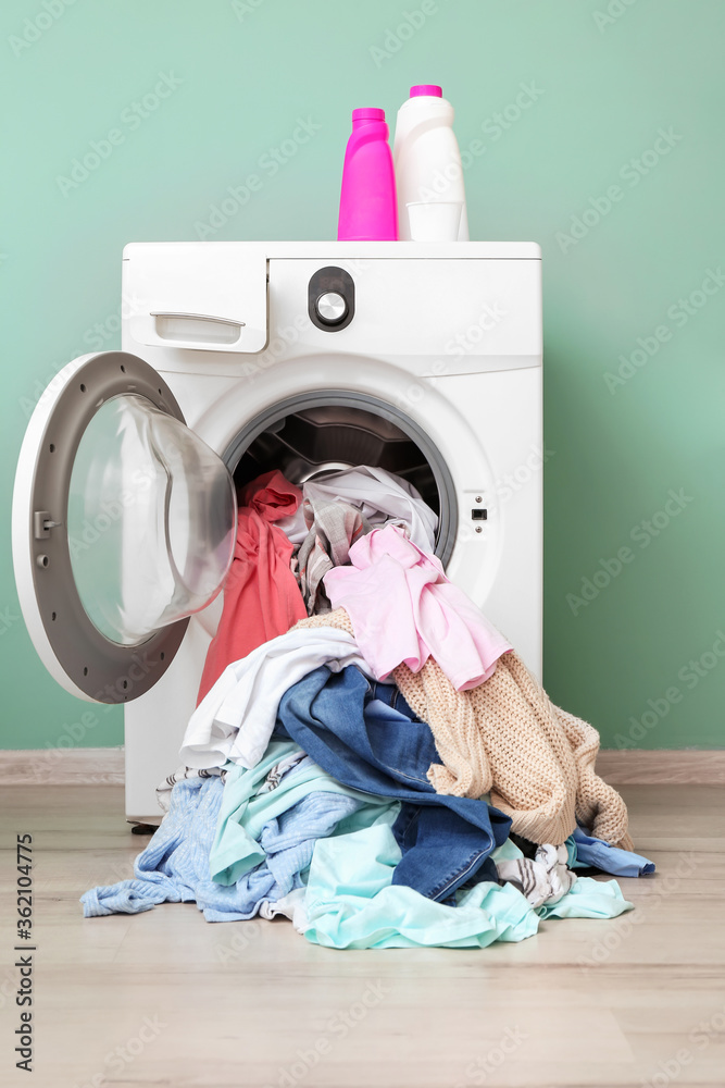 靠近彩色墙的脏衣服洗衣机