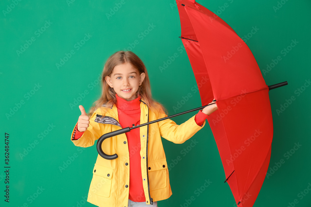 可爱的小女孩穿着雨衣，背景是雨伞