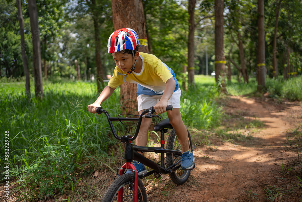 亚洲男孩正在为快乐的山地自行车训练。