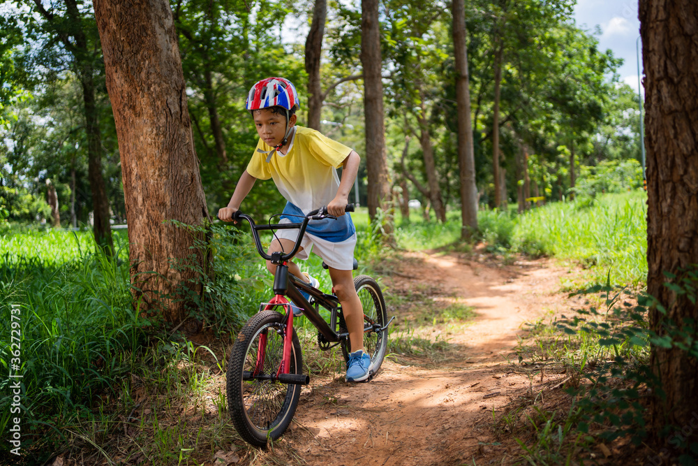 亚洲男孩正在为快乐的山地自行车进行训练。