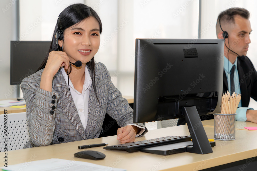戴着耳机在办公室工作的商务人士为远程客户或同事提供支持。呼叫美分