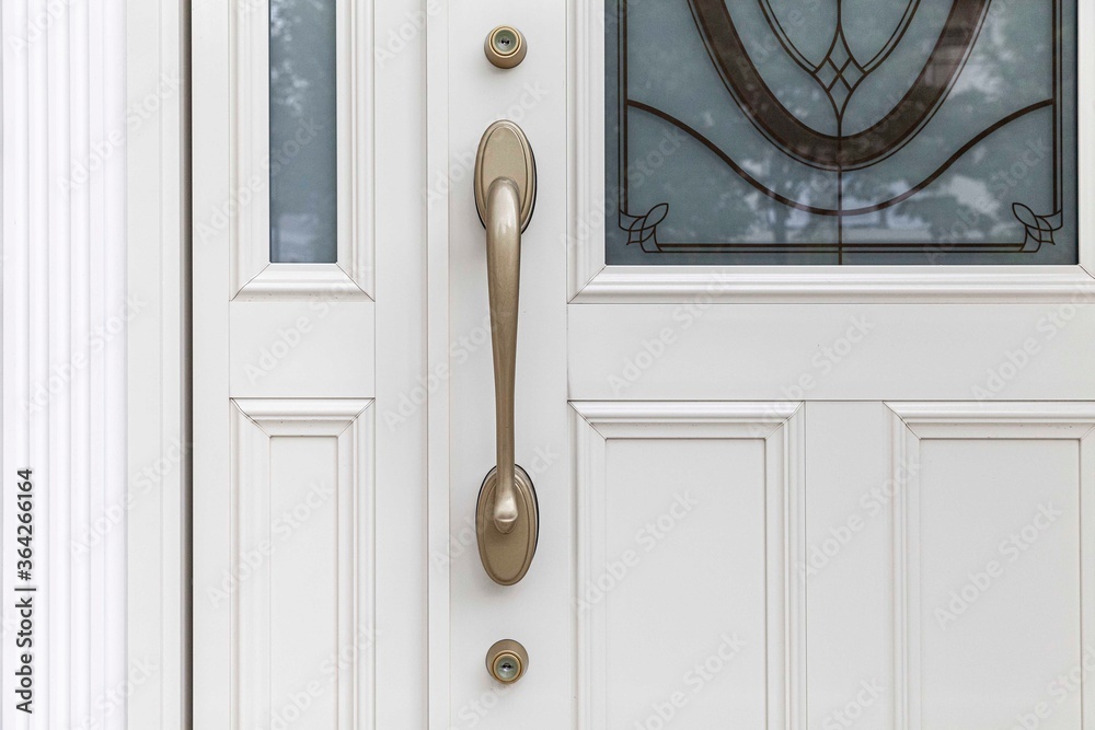 Close - up Brass door handle and white wooden door
