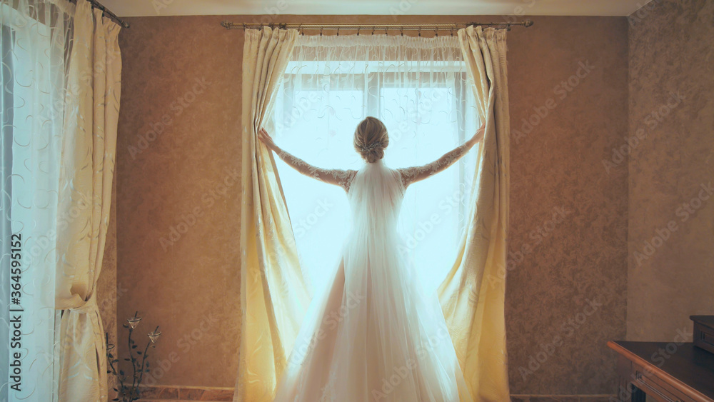 新娘打开家里窗户上的窗帘。