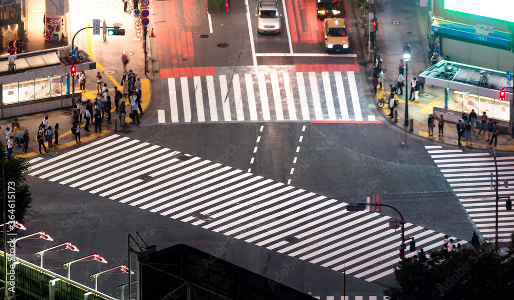 人们和车辆穿过日本东京涩谷著名的争抢十字路口，这是最繁忙的十字路口之一