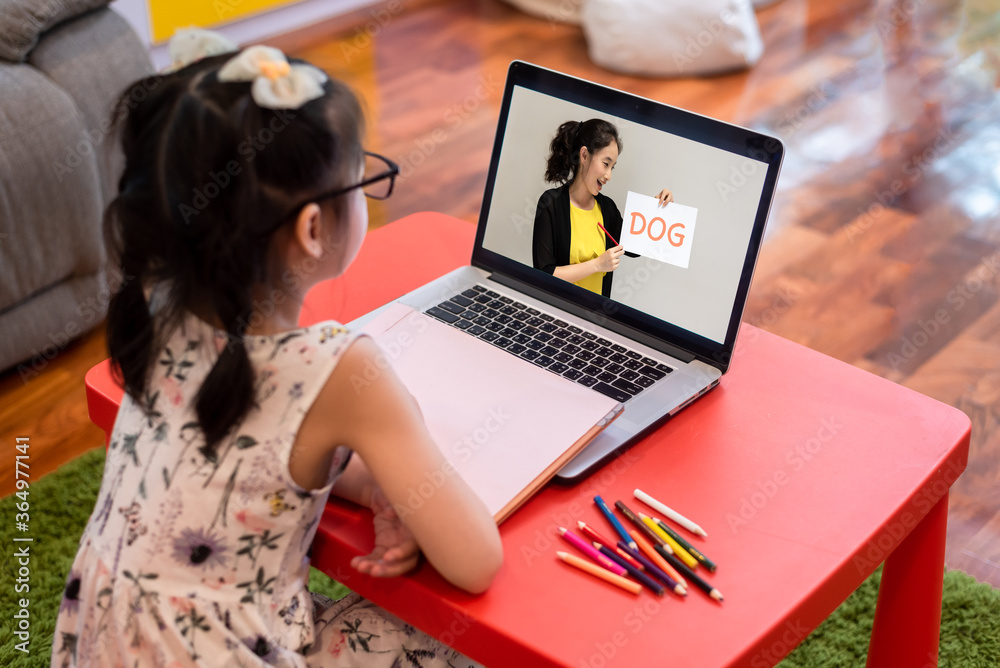 在家上网课的小女孩在封锁期间使用笔记本电脑和互联网