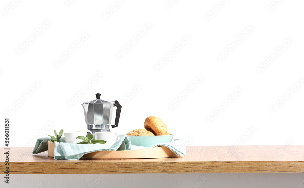 白色背景下，厨房桌子上有咖啡壶和面包的托盘