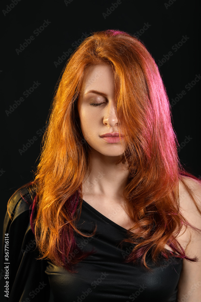 深色背景下美丽的年轻红发女人