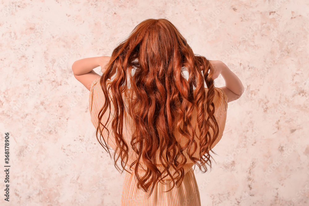 Beautiful young redhead woman on light background, back view