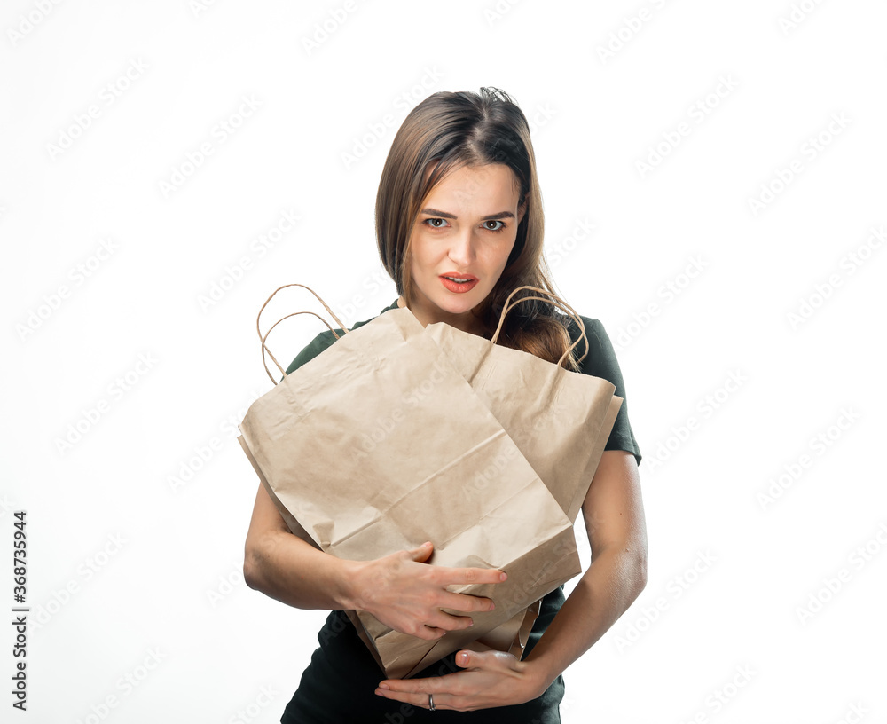 Woman is holding two grocery shopping bags on white background. Light brown paper bags in hands. Iso
