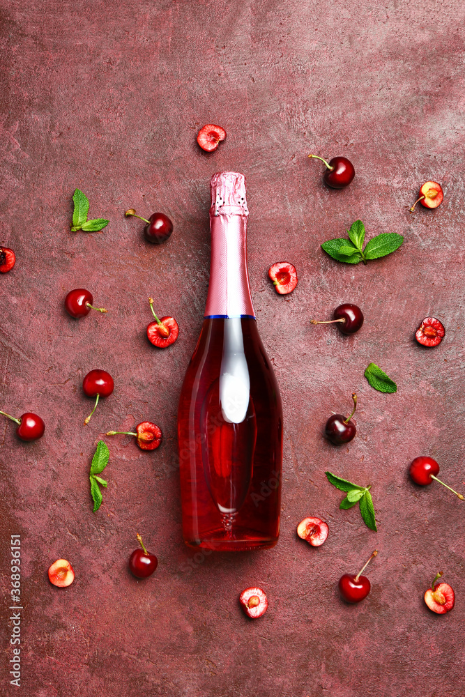 一瓶香槟和樱桃色背景