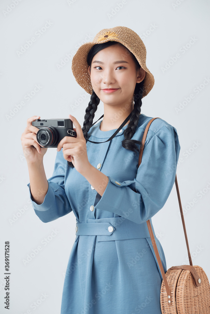 年轻漂亮的亚洲背包旅行家，用数码相机微笑，看着警察