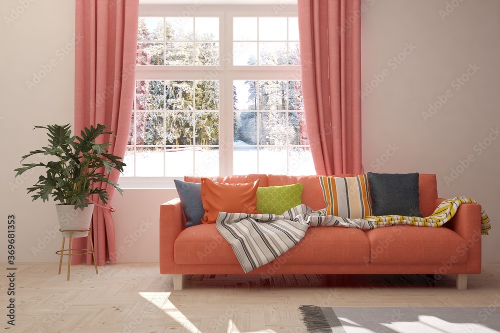 珊瑚风格的极简主义房间，配有沙发和窗户的冬季景观。斯堪的纳维亚室内设计