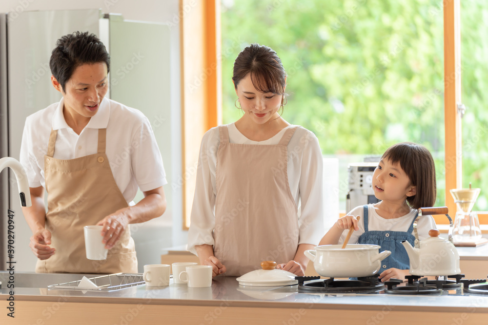 キッチンで料理を作る女の子と両親