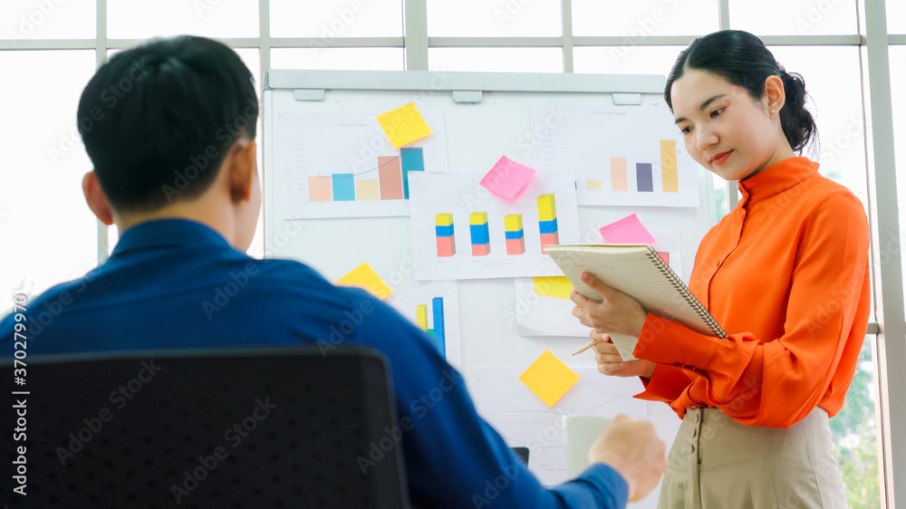 一位年轻女士在休闲办公室的白板上解释商业数据。自信的亚洲企业