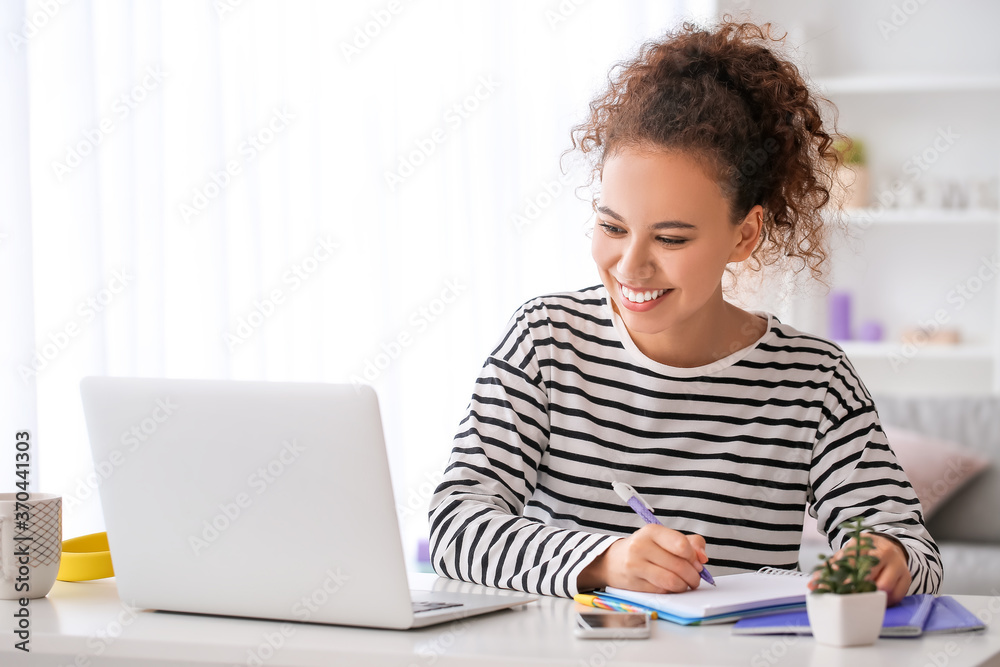 年轻女性在家使用笔记本电脑进行在线学习