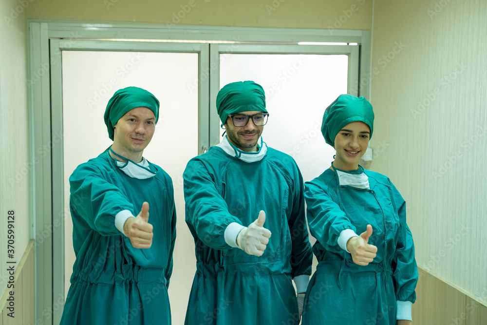 团队积极自信，自豪的外科医生站在手术室前面。