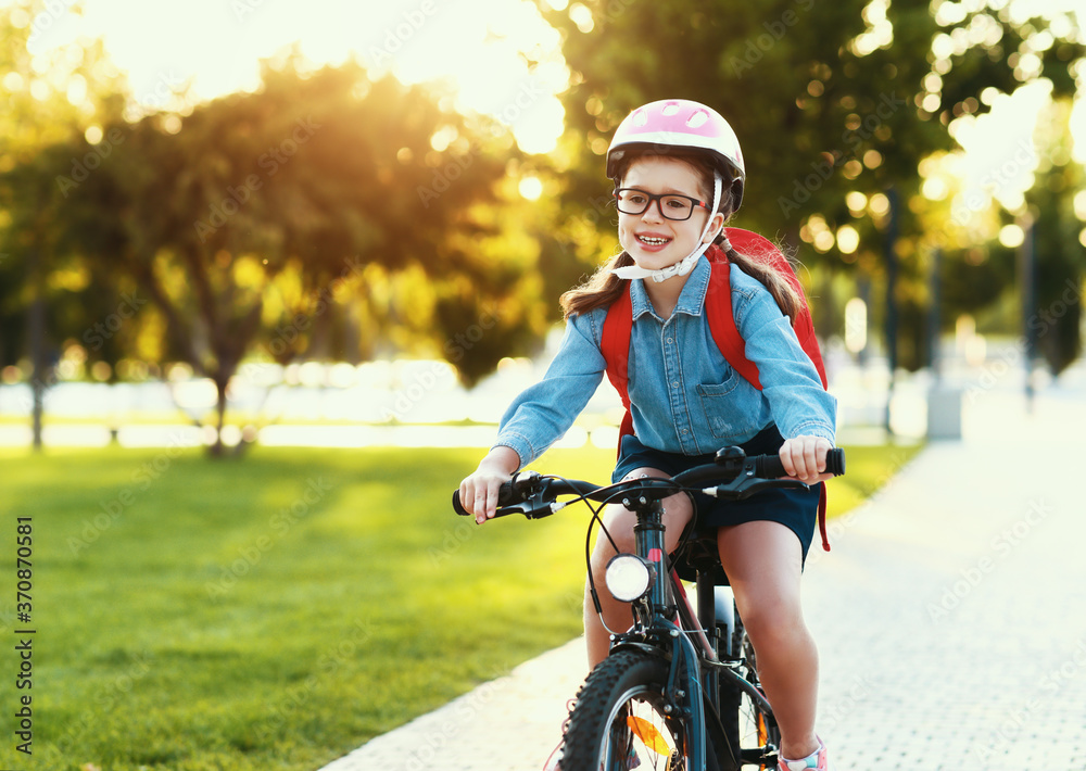 有趣的女孩骑自行车上学。